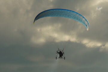 Paraglider on a flight in the clear sky to a banner