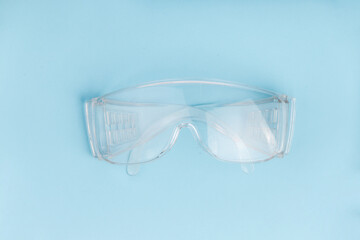 Protective glasses on blue background.