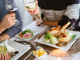 Couple Enjoying Gourmet Seafood With Glasses of Red and White Wine
