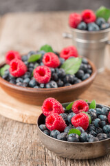 Summer Berries mix with Raspberry, Blueberry in wooden and metal dishes.