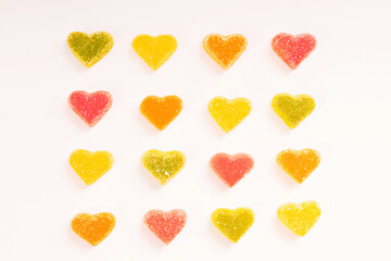 Multi-colored marmalade hearts in sugar on a white background. Marmalade sweets: Red, green and yellow sweet. Valentine's Day. Dessert. Copy space. View from above