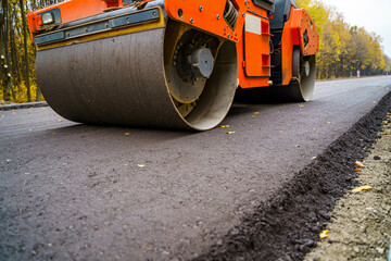 Industrial pavement truck. Laying fresh asphalt on construction site. Heavy machine industry....