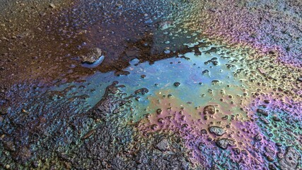 multicolored background, gasoline stains, rainbow streaks, abstract texture, wet asphalt picture, vertical fluid streams