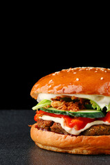 tasty burger with chicken on dark isolated background. Homemade hamburger or burger with fresh vegetables and cheese