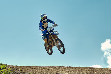 Extreme concept, challenge yourself. Extreme jump on a motorcycle on a background of blue sky with...