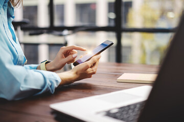 Woman pointing on smartphone screen, chatting in social networks, meeting website, searching internet, sending sms, using text messenger or online banking.