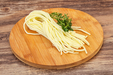 Chechil spaghetti cheese over board