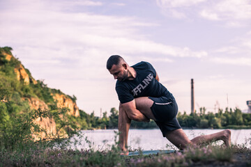 A young man doing yoga in nature. Healthy lifestyle, meditation, lifestyle concept. International Day of Yoga