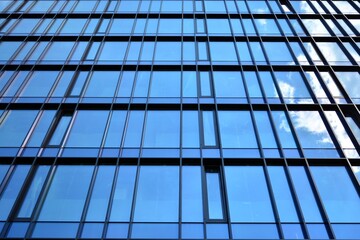 Fototapeta premium Facade texture of a glass mirrored office building. Fragment of the facade. Modern architecture of the office building.