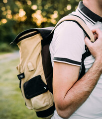  Close-up of a tourist beige hand with a black backpack a guy on his shoulder. Inspiration, new experiences, a new stage