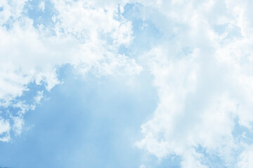 Fluffy white clouds on a clear blue background float in the spring sky. Copy space.