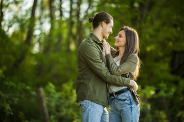 Fototapeta premium Happy young couple hugging and laughing outdoors in the park