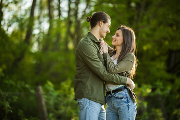 Happy young couple hugging and laughing outdoors in the park