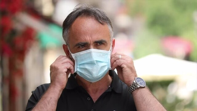 Slow motion di uno moro che si toglie la mascherina protettiva e ritrova la felicit&agrave; con un sorriso