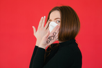 A woman in a mask indicates stopping the spread of the COVID-19 virus.. The concept of preventing the spread of the epidemic and treating coronavirus.