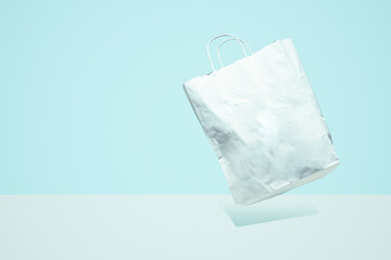 Flying shopping paper bag with purchases. Concept of consumerism, ease of shopping. Copy space trend pastel colors.