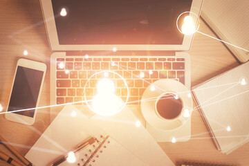 Social network hologram drawings over computer on the desktop background. Top view. Double exposure.