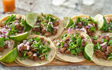 wooden tray with carne asada tacos on corn tortilla