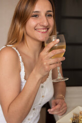 Beautiful young girl having dinner with a glass of champagne