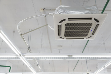 Rectangular ceiling air conditioning appliance. Fan Coil hanging on ceiling. industrial climate gear