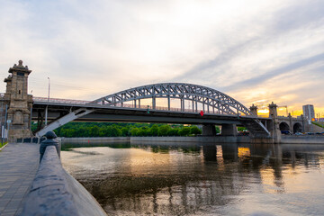 Evening view the bridge over the river Moskva or Moscow. Beautiful reflections of the colorful sky over the surface of the water. Shot at golden hour. 