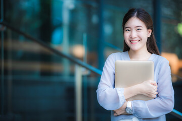 happy and smiling Asian business woman worker with laptop at her office, creative freelance business working concept