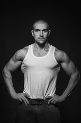 Sporty guy posing in the Studio on the background. Sports, beauty, black and white photography