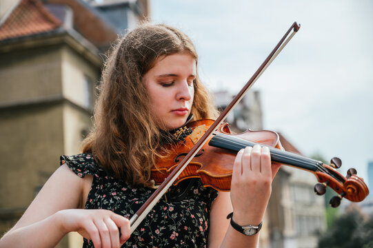 Young woman playing the violin outdoors
