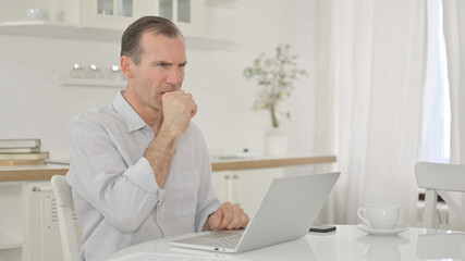Naklejka premium Sick Middle Aged Man with Laptop Coughing at Home