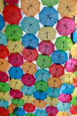Fototapeta na wymiar Colourful sun umbrellas against the blue sky. Street decoration. 