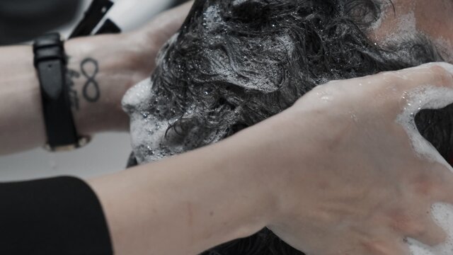 Stylist wash customer head in barbershop. Close up © Oleksii