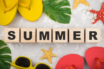 summer flip flop shoes, leaf and sunglasses on grey background