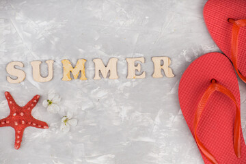 summer flip flop shoes, leaf and sunglasses on grey background