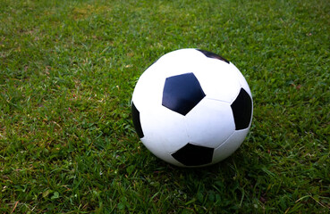 Fototapeta na wymiar Children's soccer ball white on the green grass