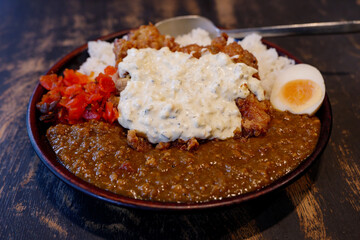 Close up view at Japanese Fried Chicken Nanban style curry with rice, boiled egg and red pickled vegetable. 