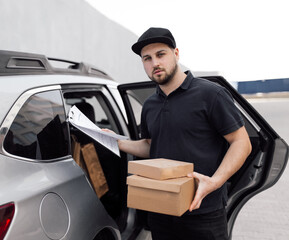 Smiling delivery man standing in front of his vehicle