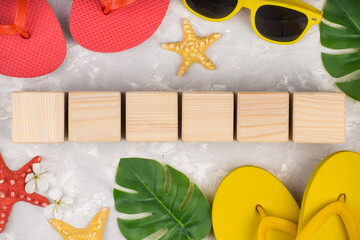 summer flip flop shoes, leaf and sunglasses on grey background