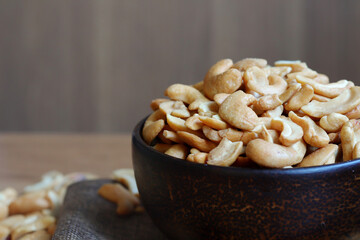 Cashew nuts in a wooden bowl on the table.