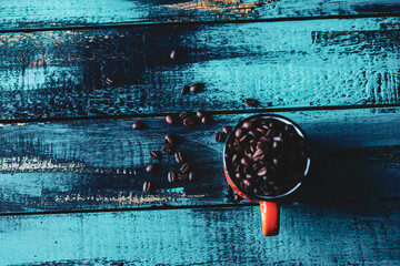 cyan old wooden table orange mug filled with roasted coffee beans