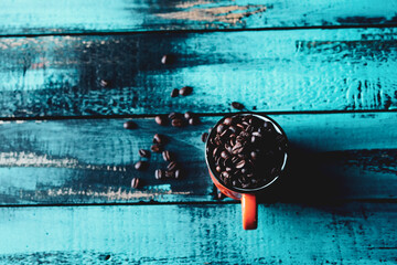 cyan old wooden table orange mug filled with roasted coffee beans