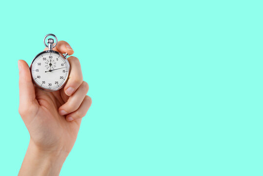 stopwatch hold in hand, button pressed, aqua menthe backgroun