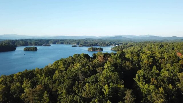 Flyover forest lake Keowee with Great Smoky Mountains in the background. Aerial view. RV, camp, vacation.