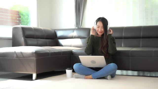 Woman at Home Sitting in the Ground Listening to Music. Static.