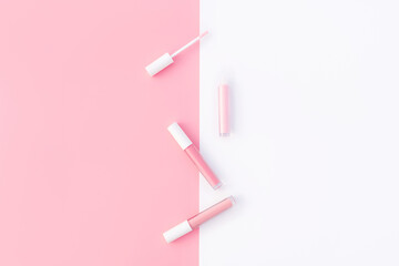 Trendy design template with tender pink lip gloss layout on pastel pink and white background. Flat lay style. Copy space. Mockup for your design.
