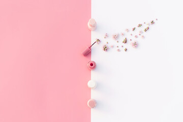 Trendy design template with tender pink nail polish layout with small flowers decoration on pastel pink and white background. Flat lay style. Copy space. Mockup for your design.