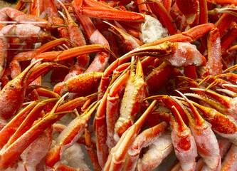Crab legs on ice on display in the seafood section of a grocery store.