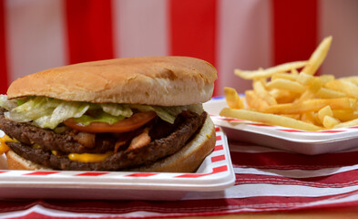Great big All American hamburger with bacon, lettuce, onions, ceese and bacon on a bun.