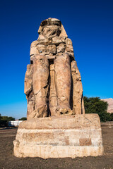 It's Closeup of the Colossus of Memnon, massive stone statue of Pharaoh Amenhotep III, Luxor, Egypt