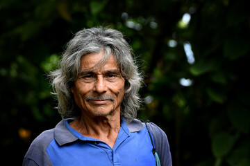 Portrait of a coffee worker in Costa Rica, smiling under the sun, with a blurred background