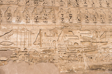 Fototapeta na wymiar It's Hieroglyphs of the Medinet Habu (Mortuary Temple of Ramesses III), West Bank of Luxor in Egypt.